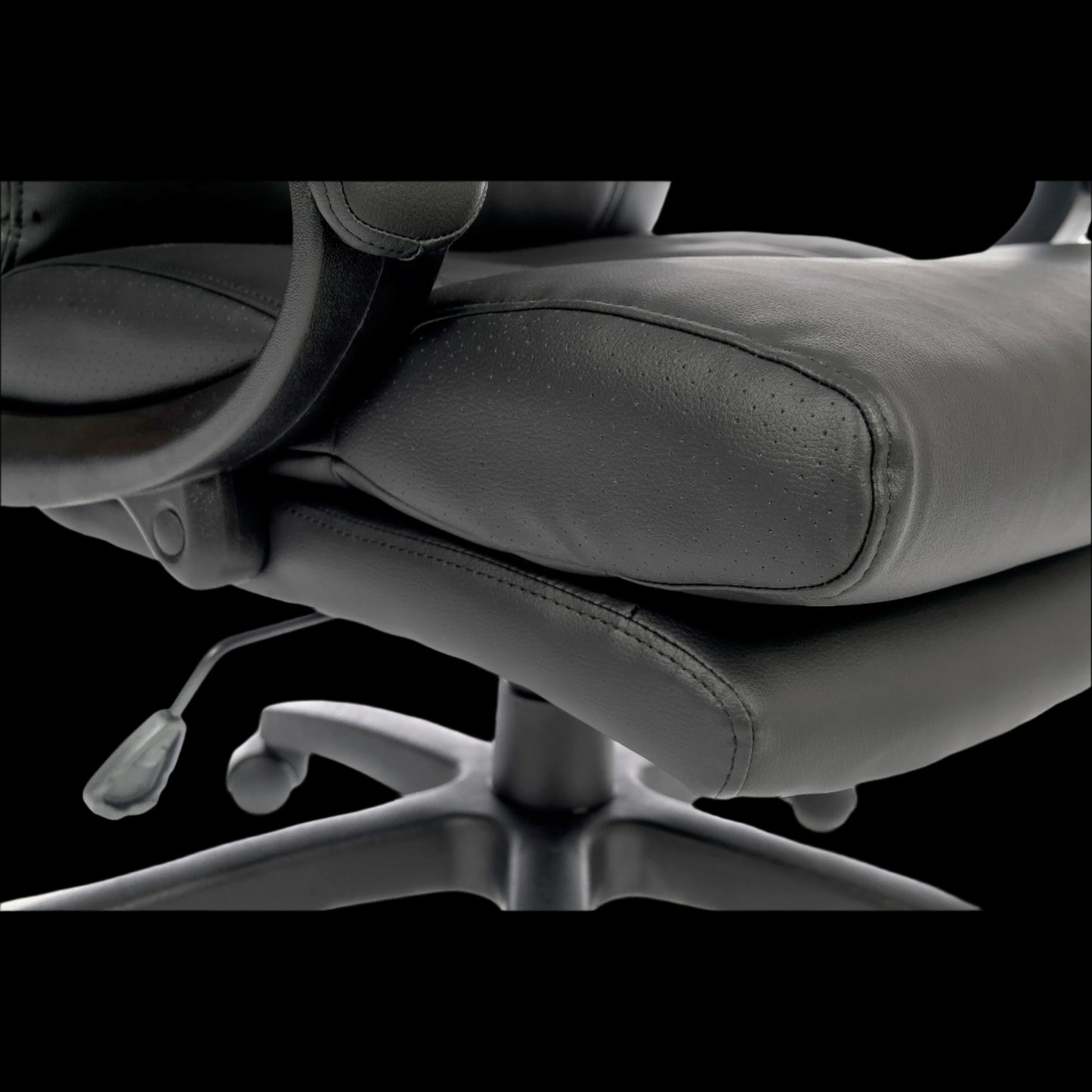 Close-up of a black office chair with a black background