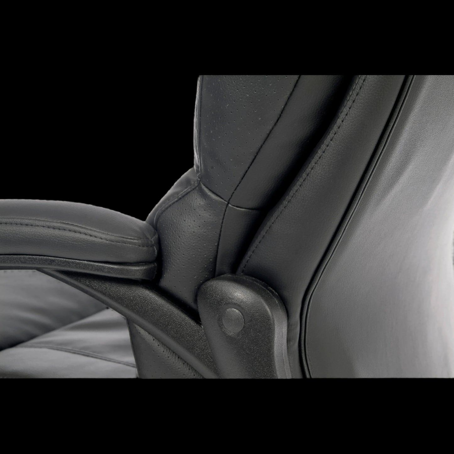 Close-up of a black leather chair with armrests on a black background