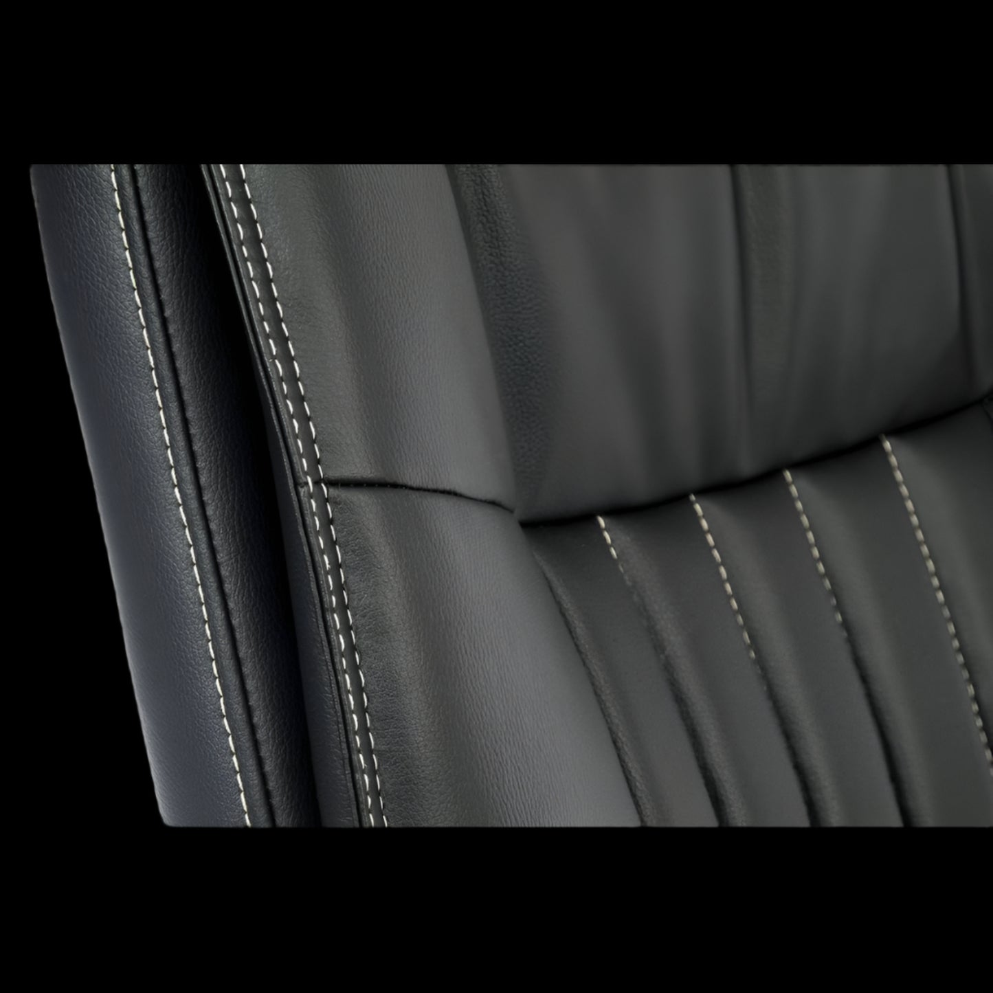 Close-up of a black leather office chair seat with visible stitching.