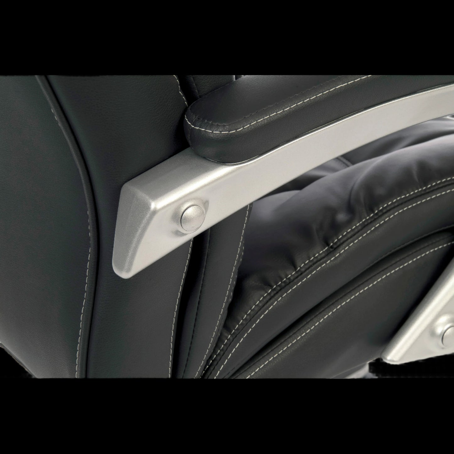 Close-up of a black leather seat with a silver metal handle.