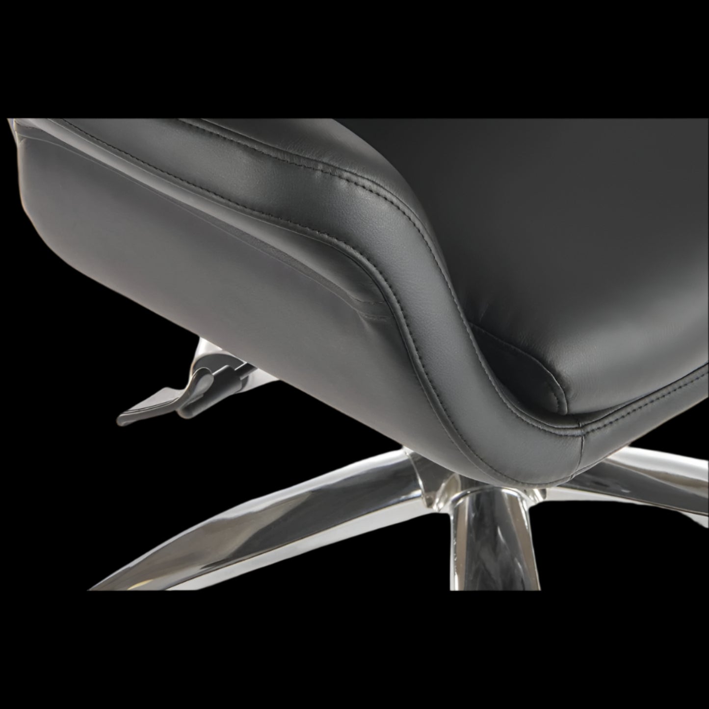 Close-up of a black office chair with a metallic base on a black background