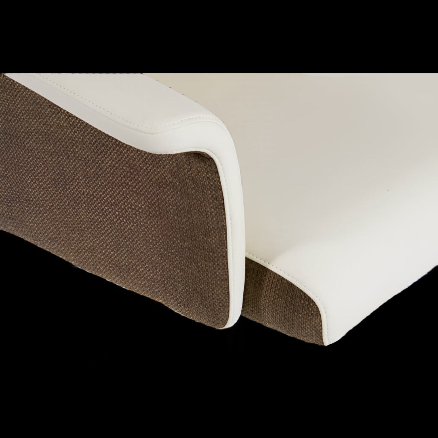 Close-up of a brown and white fabric edge on a black background