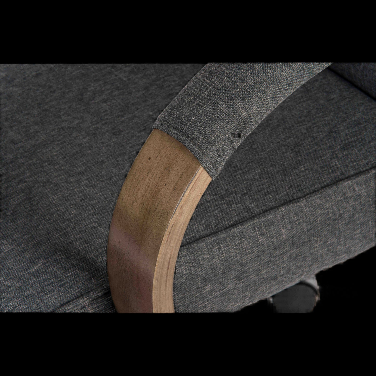 Close-up of a gray garment with wooden armrests on a black background