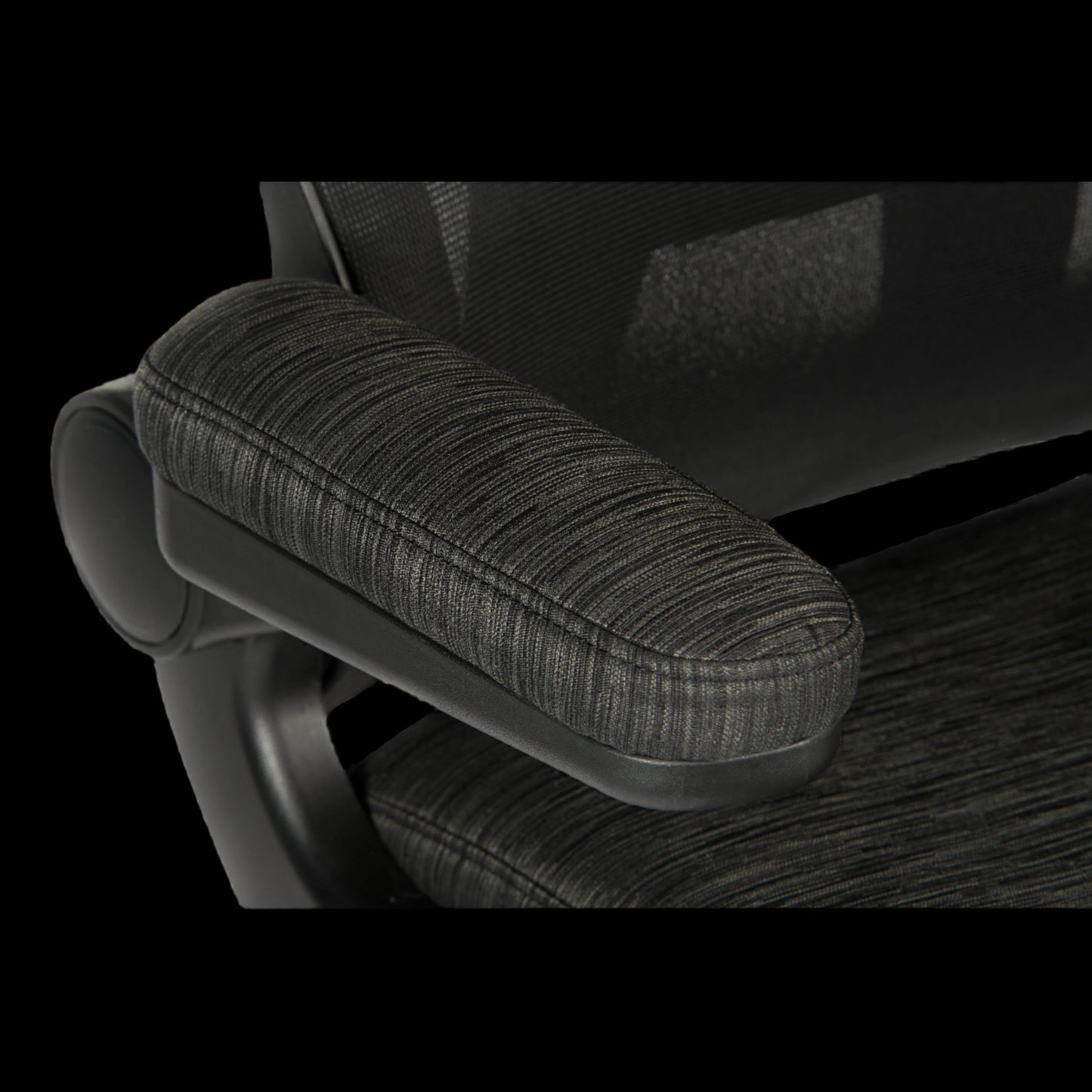 Close-up of a textured armrest on an office chair with a black background