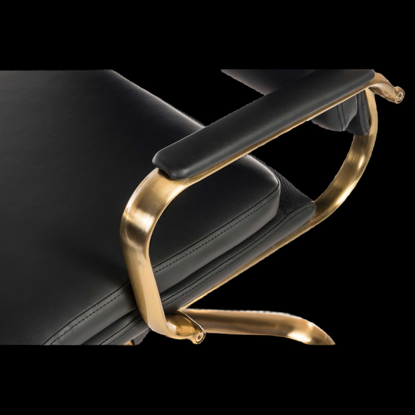 Black leather chair with gold metal armrest on a black background