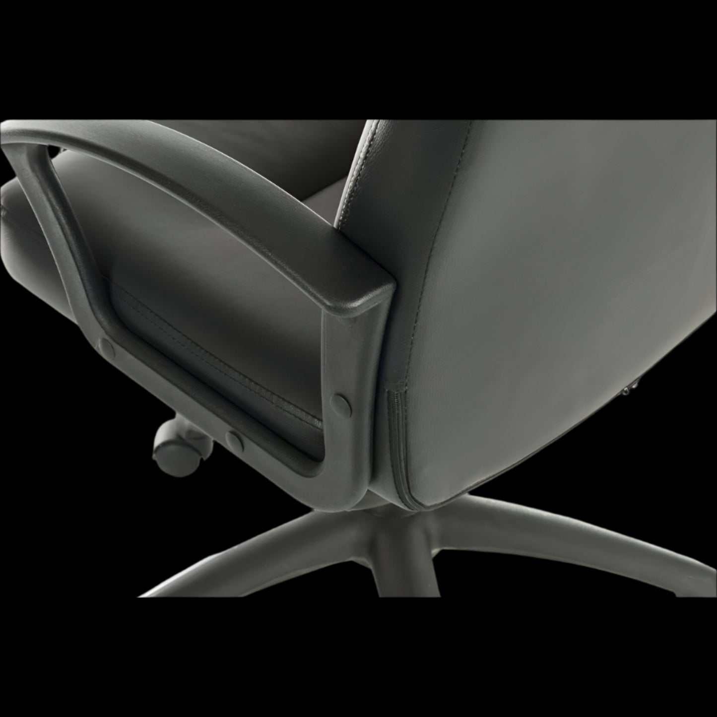 Close-up of a black office chair with a black background