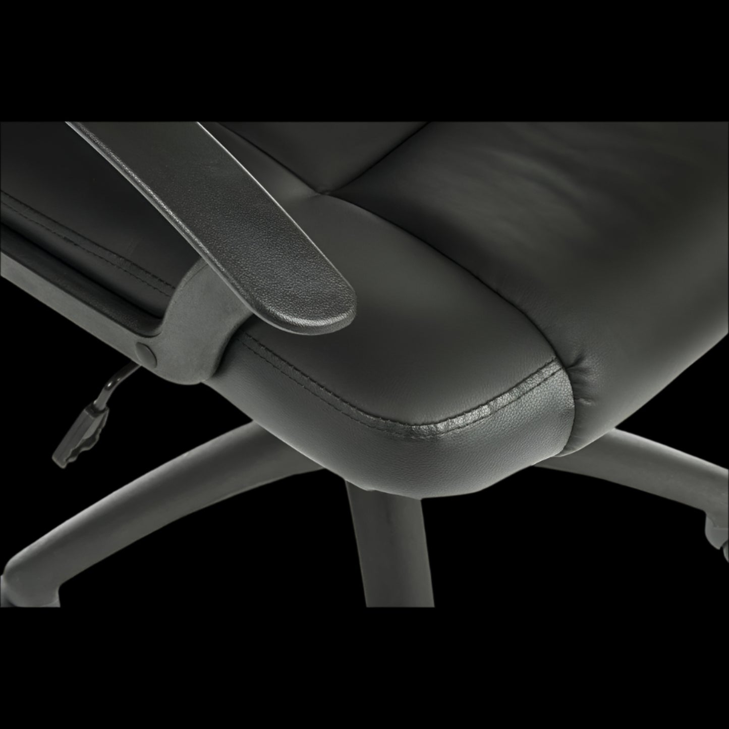 Close-up of a black office chair with armrests on a black background
