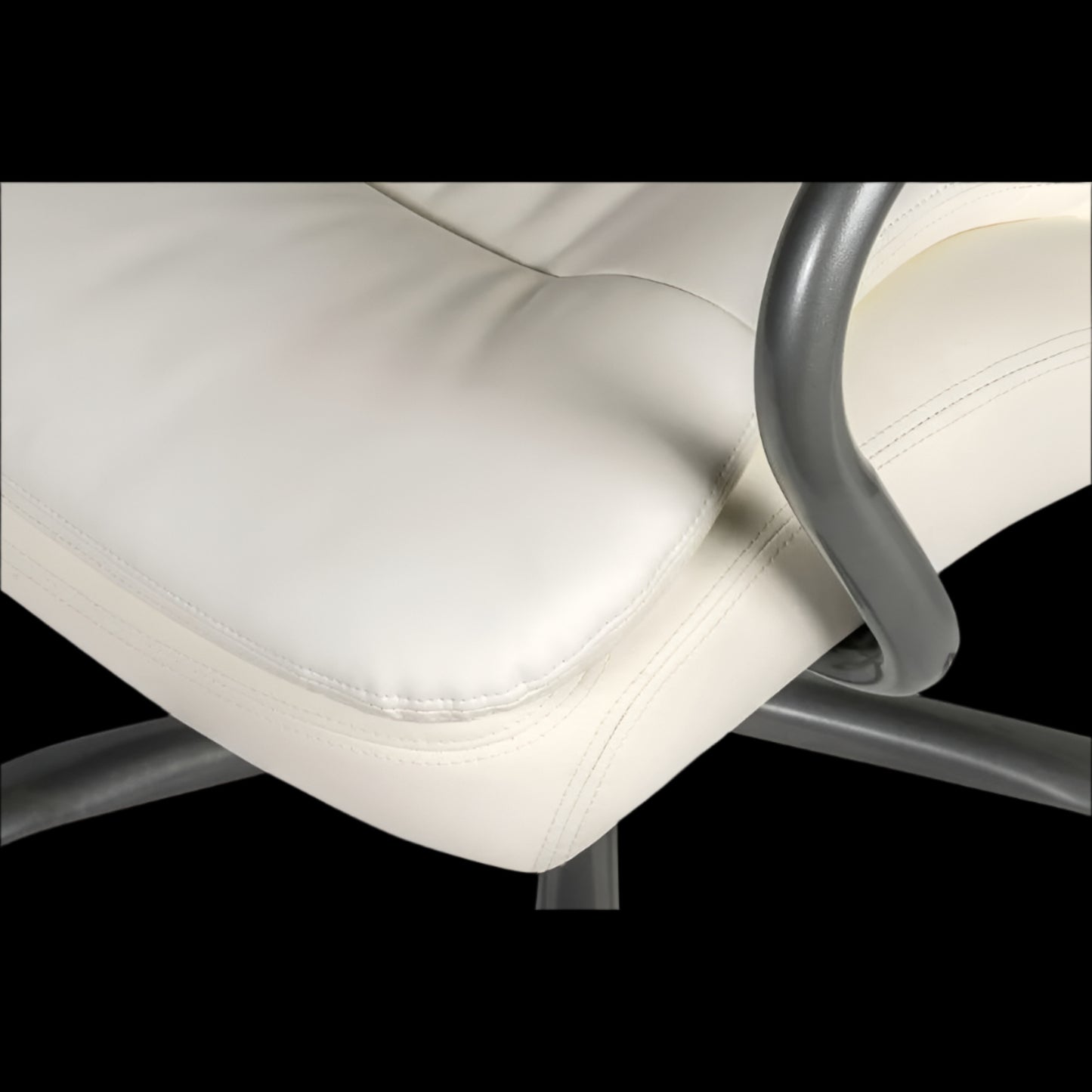 Close-up of a white office chair with a black background