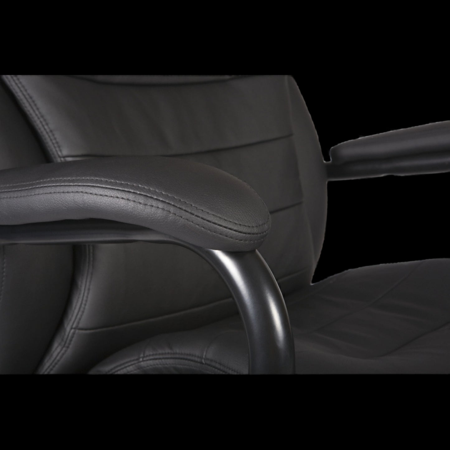 Close-up of a black office chair with armrests on a black background