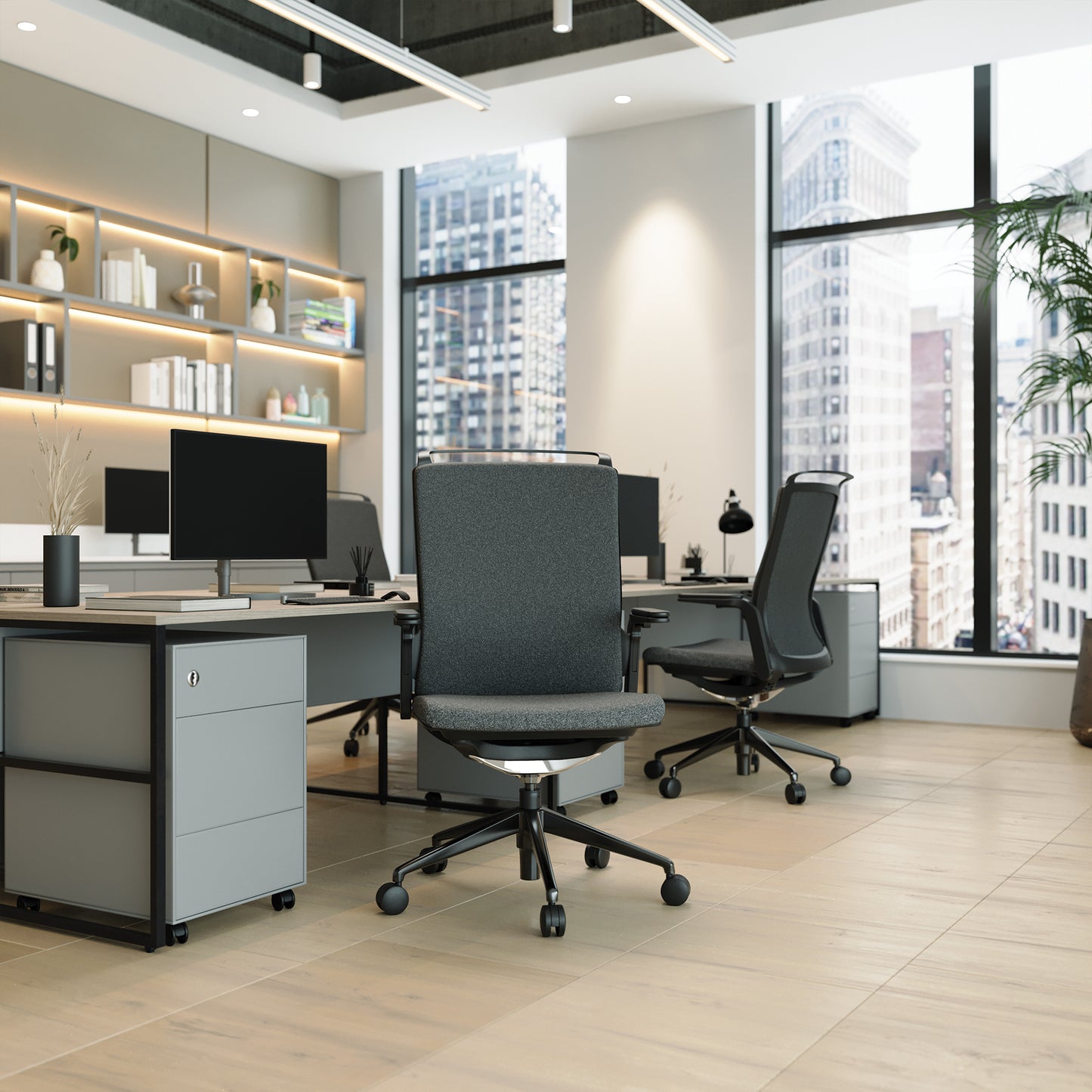 Modern office setup with desks, chairs, and large windows overlooking a cityscape.