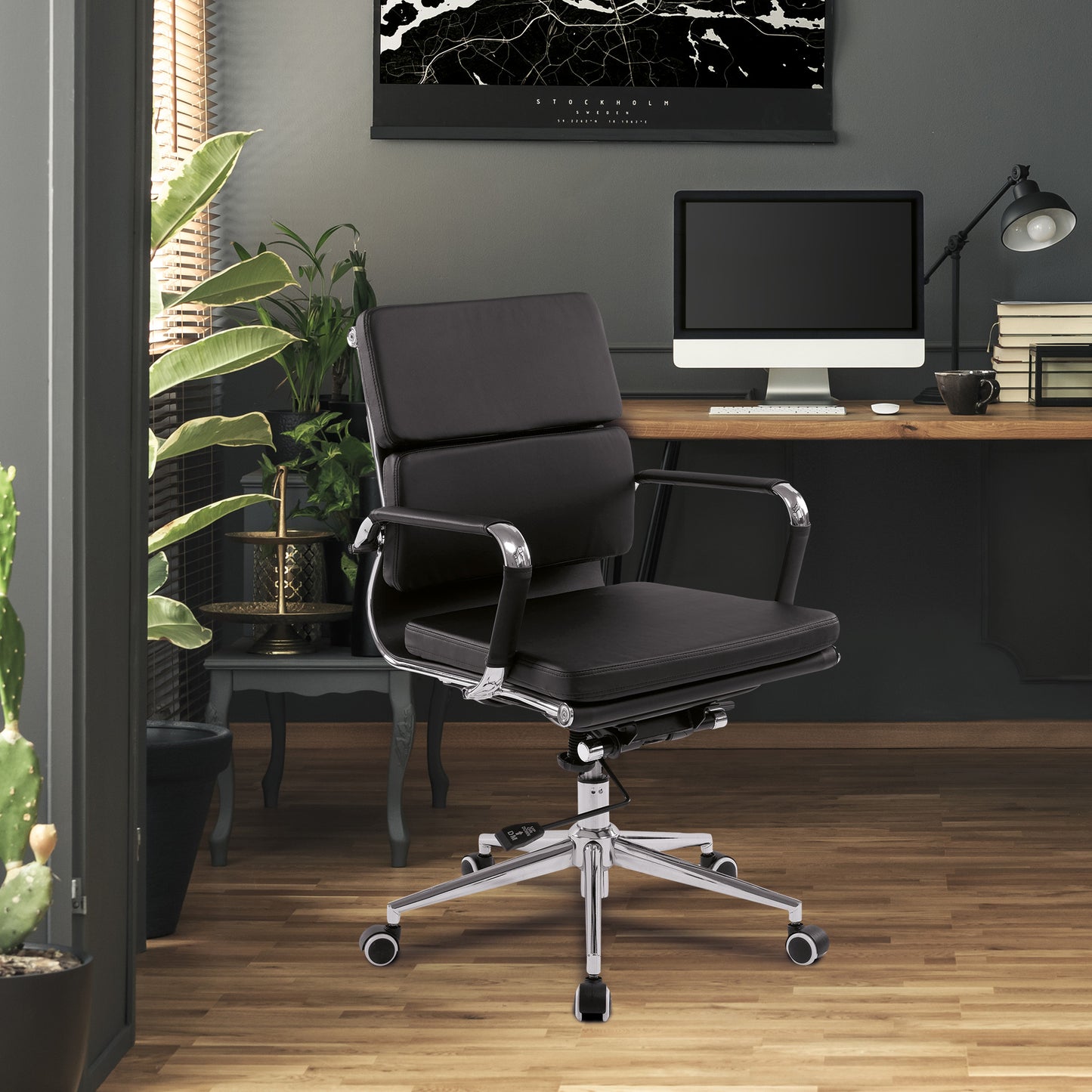 Black office chair in a modern office setting with a desk and computer.