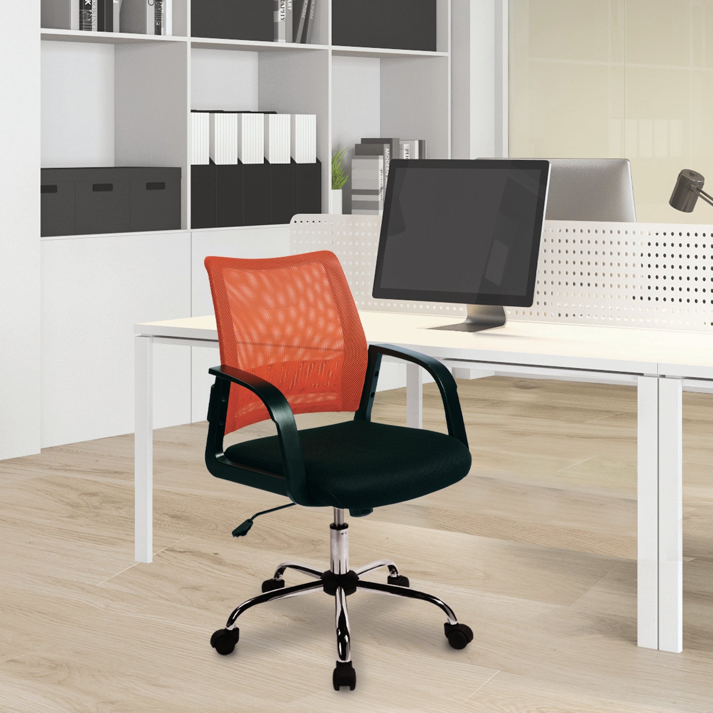 Red office chair in front of a white desk with computer equipment in an office setting.