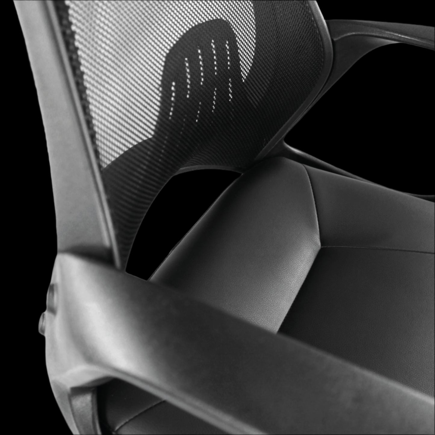 Close-up of a black office chair with mesh backrest and armrests on a black background