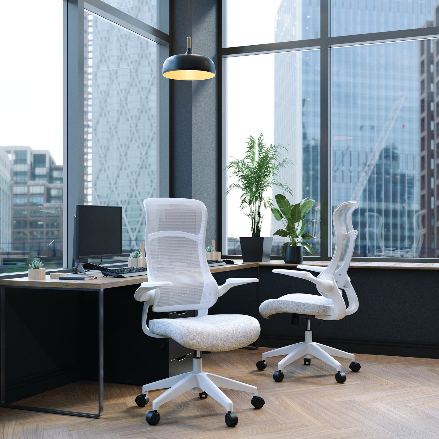 Modern office setup with ergonomic chairs and a desk in front of large windows.