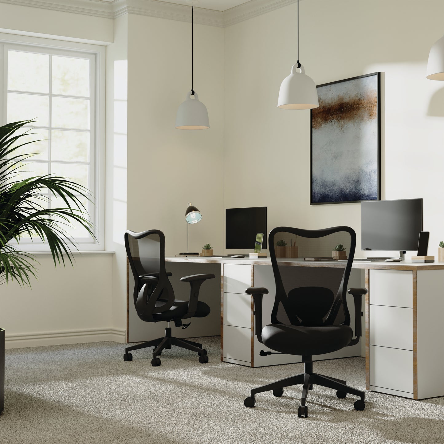 Modern office setup with two black chairs, a desk, and computer monitors.