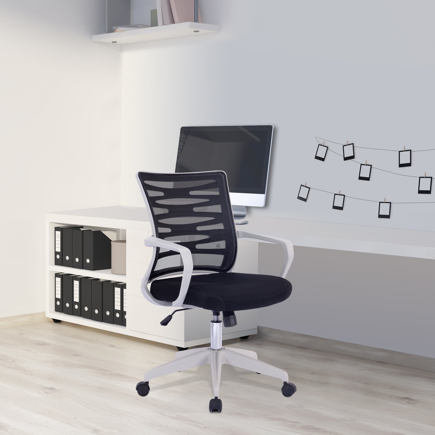 Black office chair in a modern office setting with a desk and computer monitor.