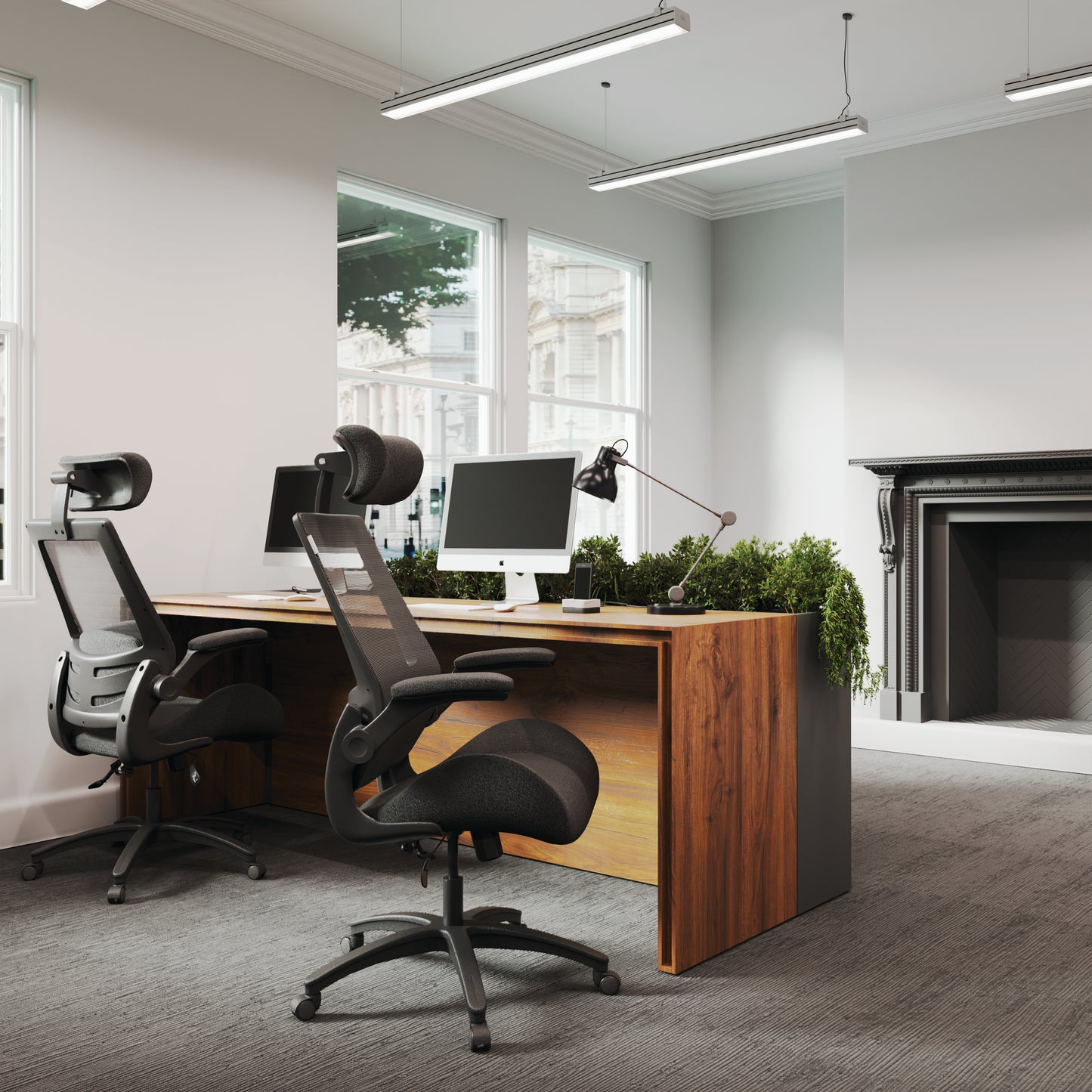 Modern office setup with a wooden desk, computer monitors, and ergonomic chairs.