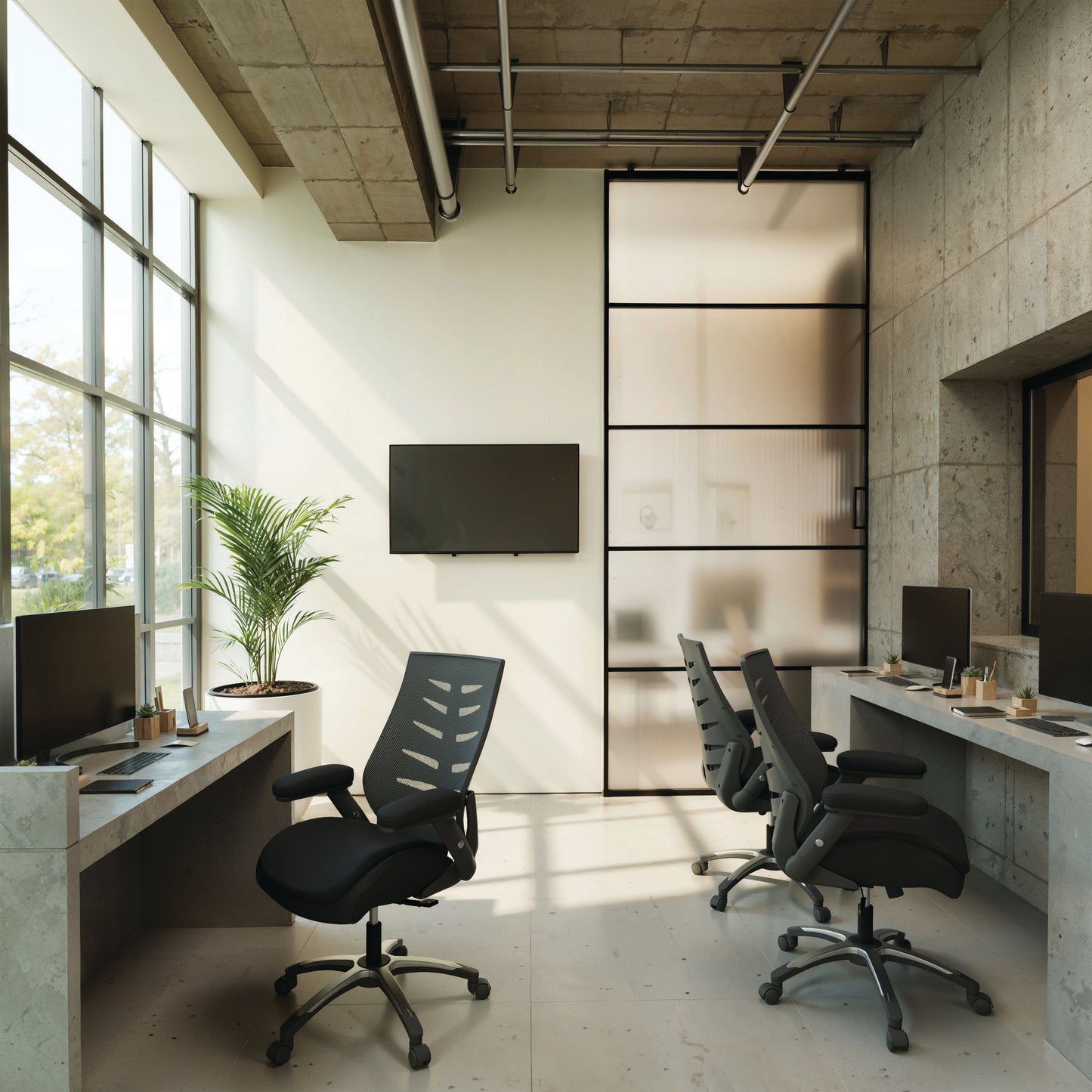 Modern office space with desks, chairs, and large windows.