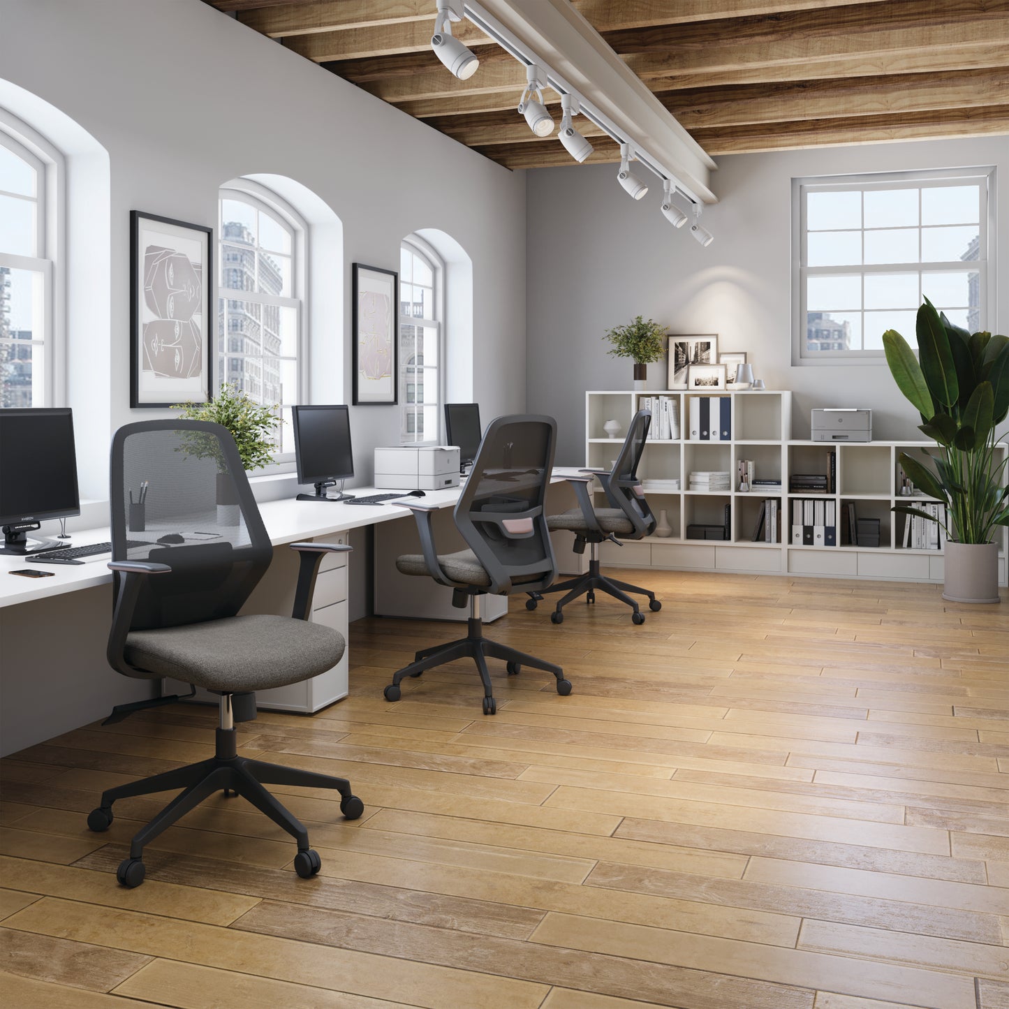 Modern office space with desks, chairs, and bookshelves.