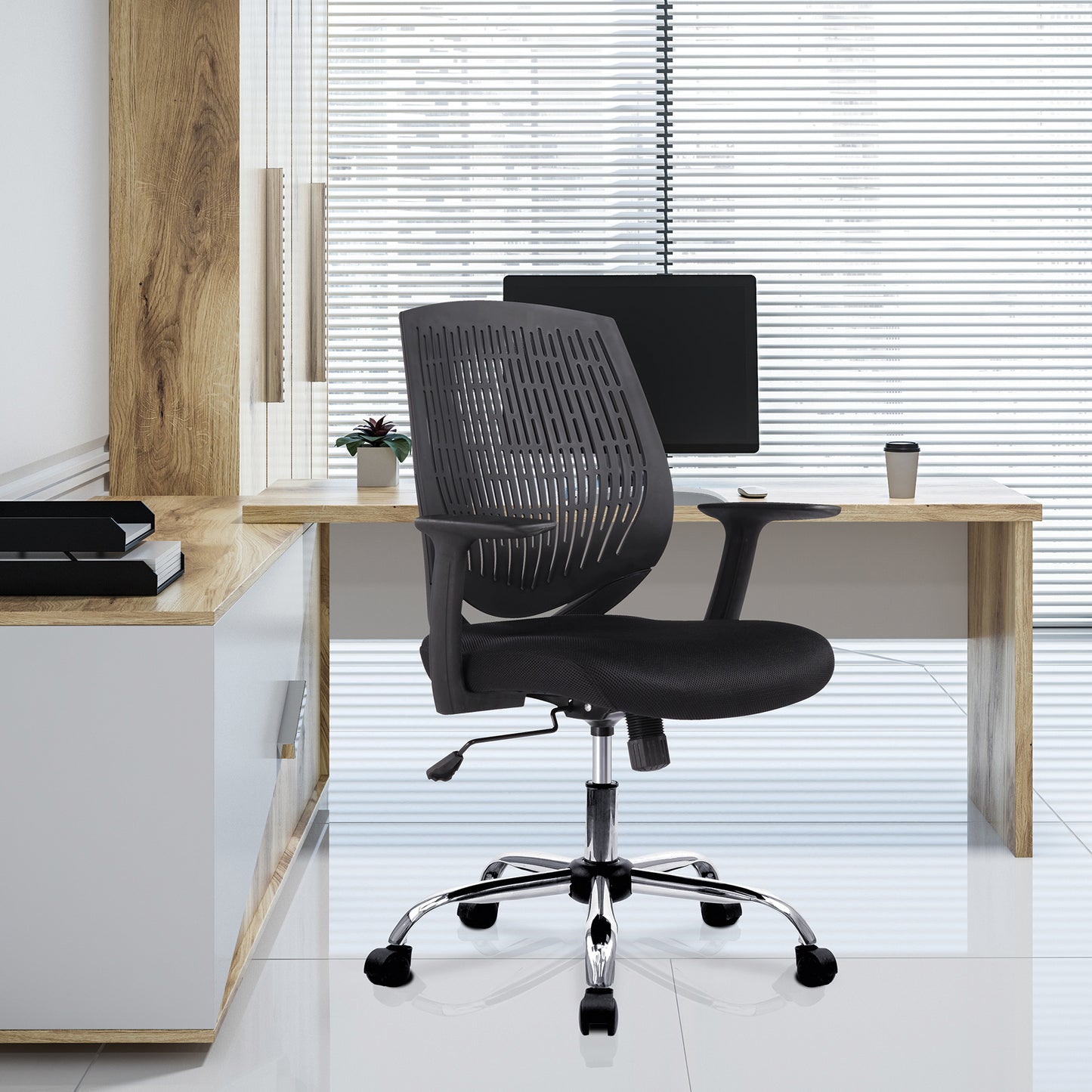 Black office chair in front of a wooden desk with a computer setup.