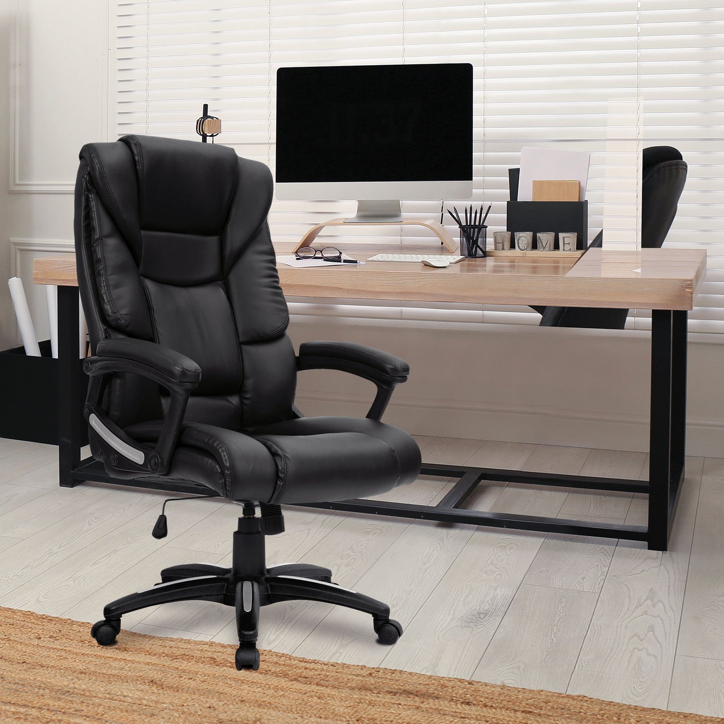 Black office chair in front of a wooden desk with a computer setup.