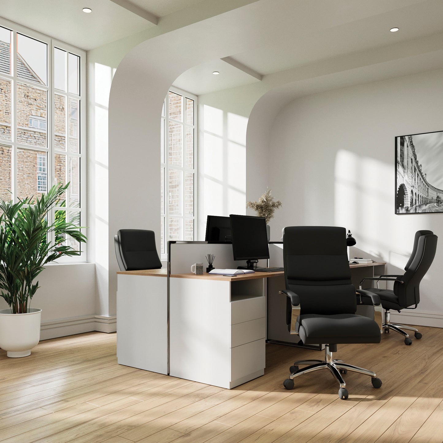 Modern office setup with desks, chairs, and large windows.