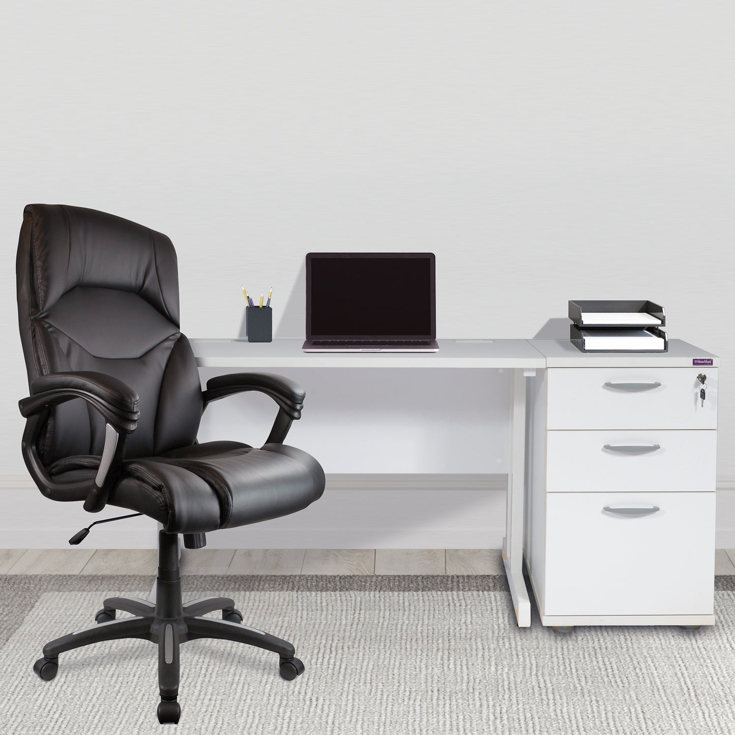 Black office chair in front of a white desk with a laptop and office supplies.