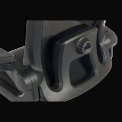 Close-up of a black office chair armrest on a black background