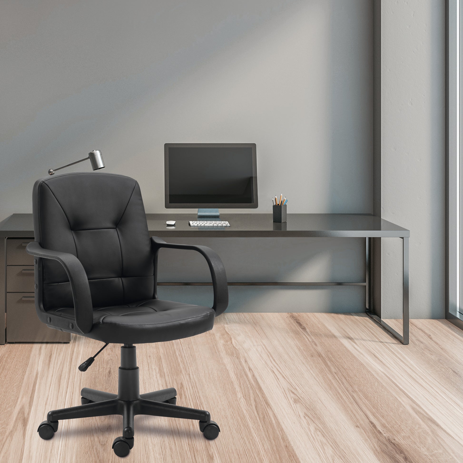 Modern office setup with black chair and desk against a green wall.