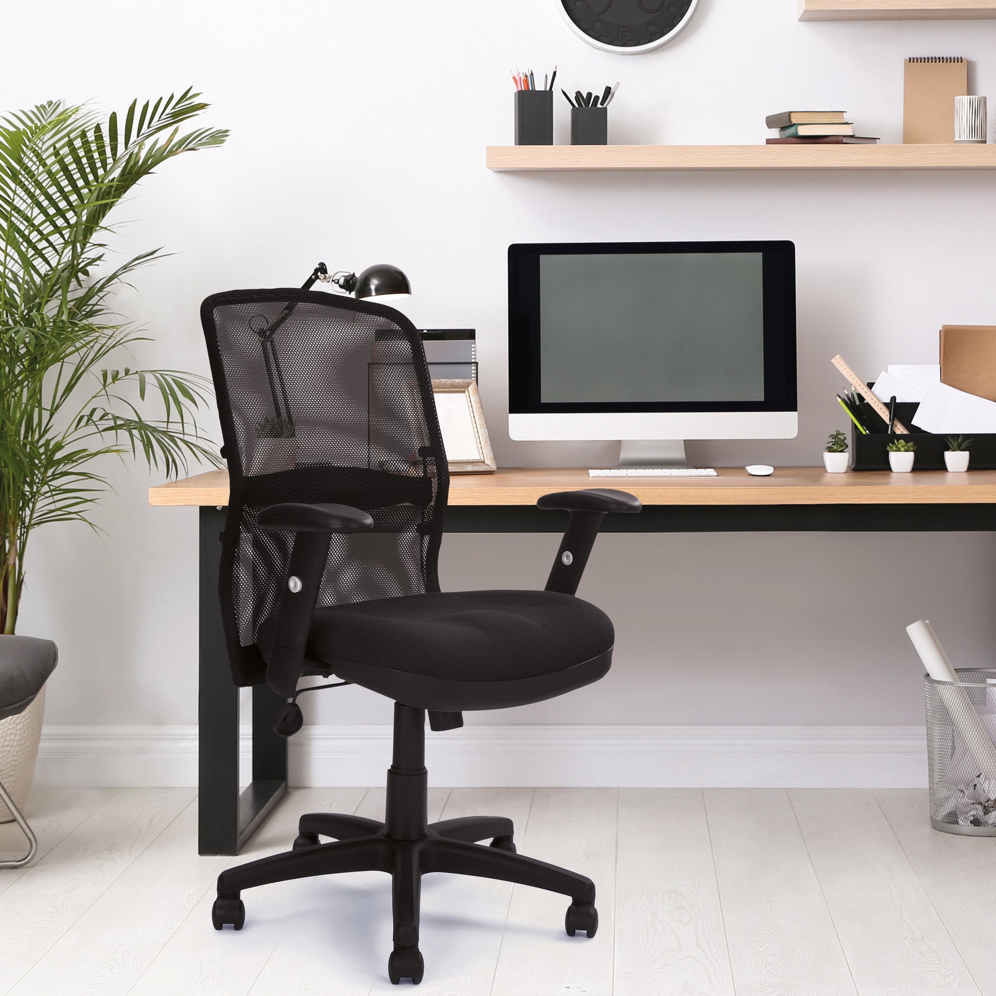 Modern office setup with a black chair, desk, and computer monitor.