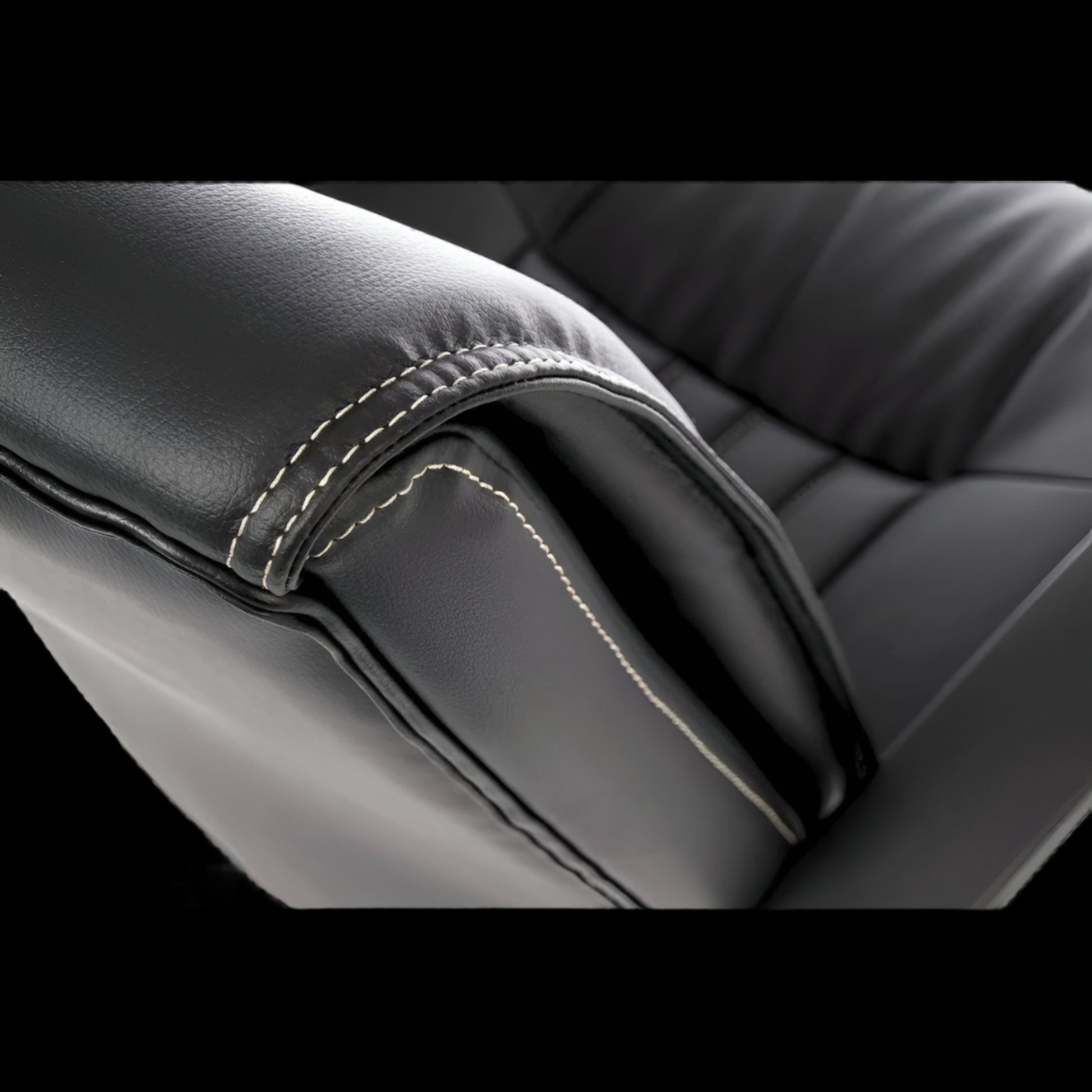 Close-up of black leather office chair seat with visible stitching detail.