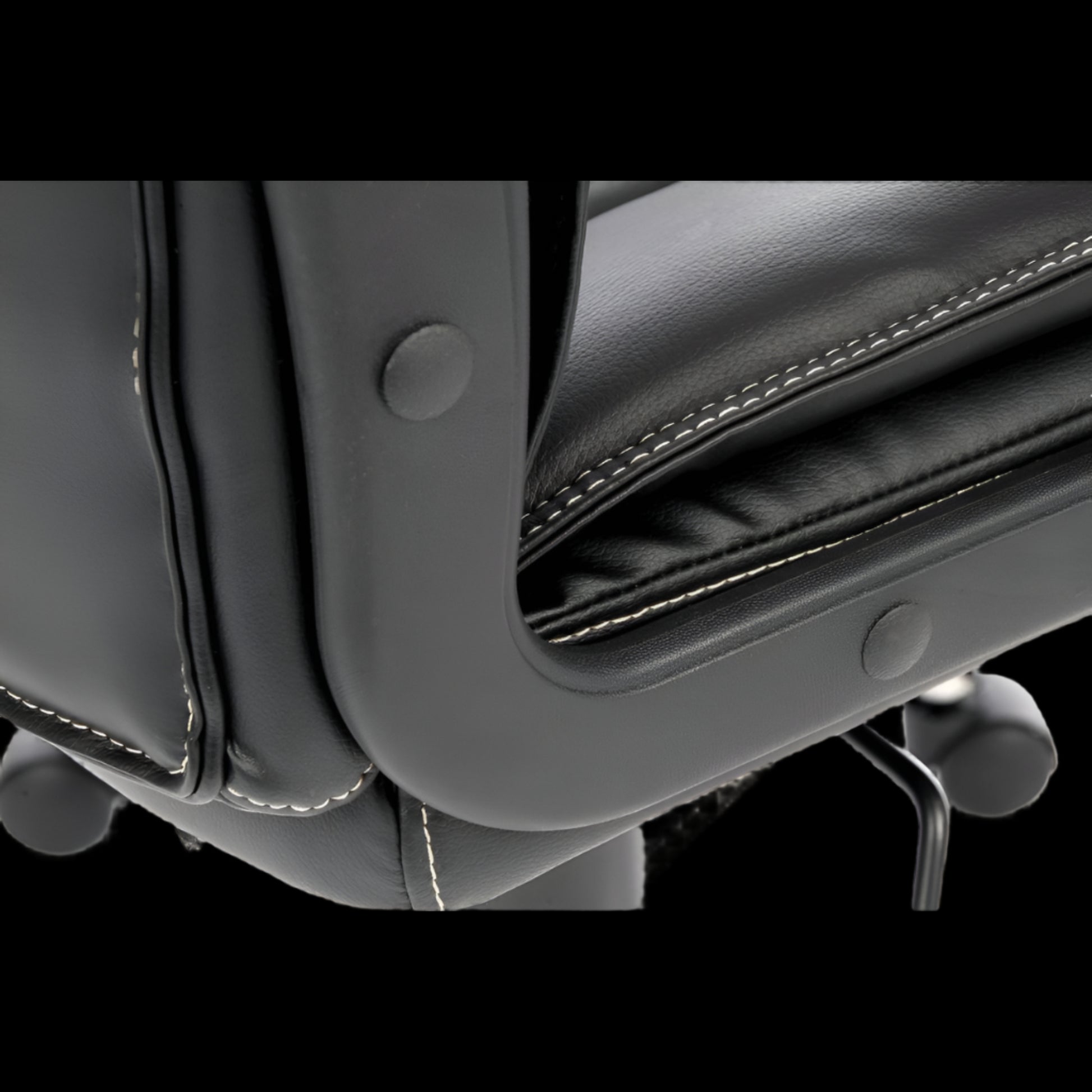 Close-up of a Black office chair with visible stitching and armrests.