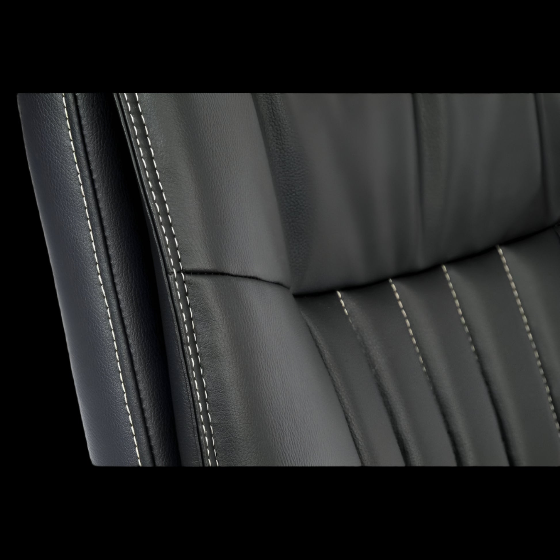 Close-up of a black leather office chair seat with visible stitching.