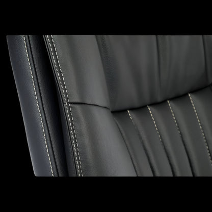 Close-up of a black leather office chair seat with visible stitching.