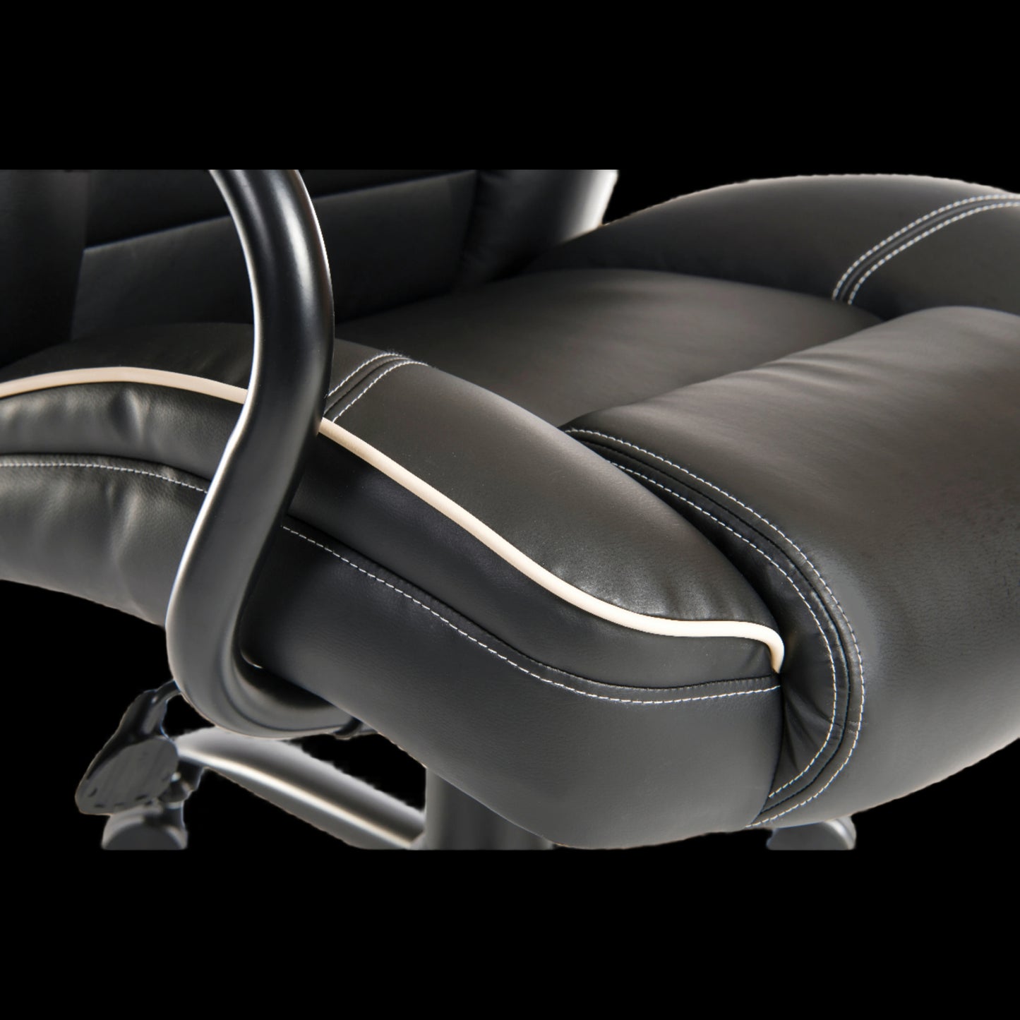Close-up of a black leather office chair with armrests on a black background