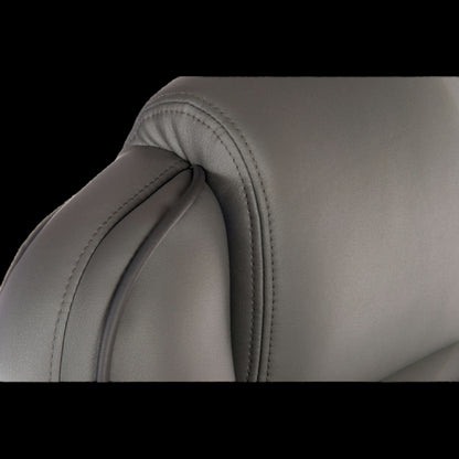 Close-up of a gray leather chair with visible stitching on a black background