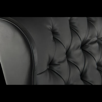 Close-up of a black tufted sofa cushion