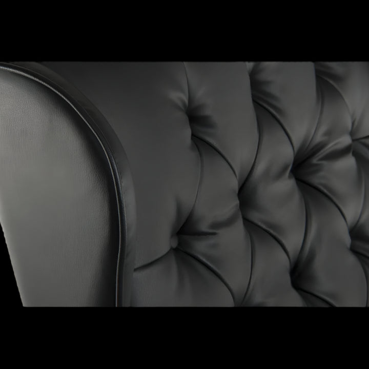 Close-up of a black tufted sofa cushion