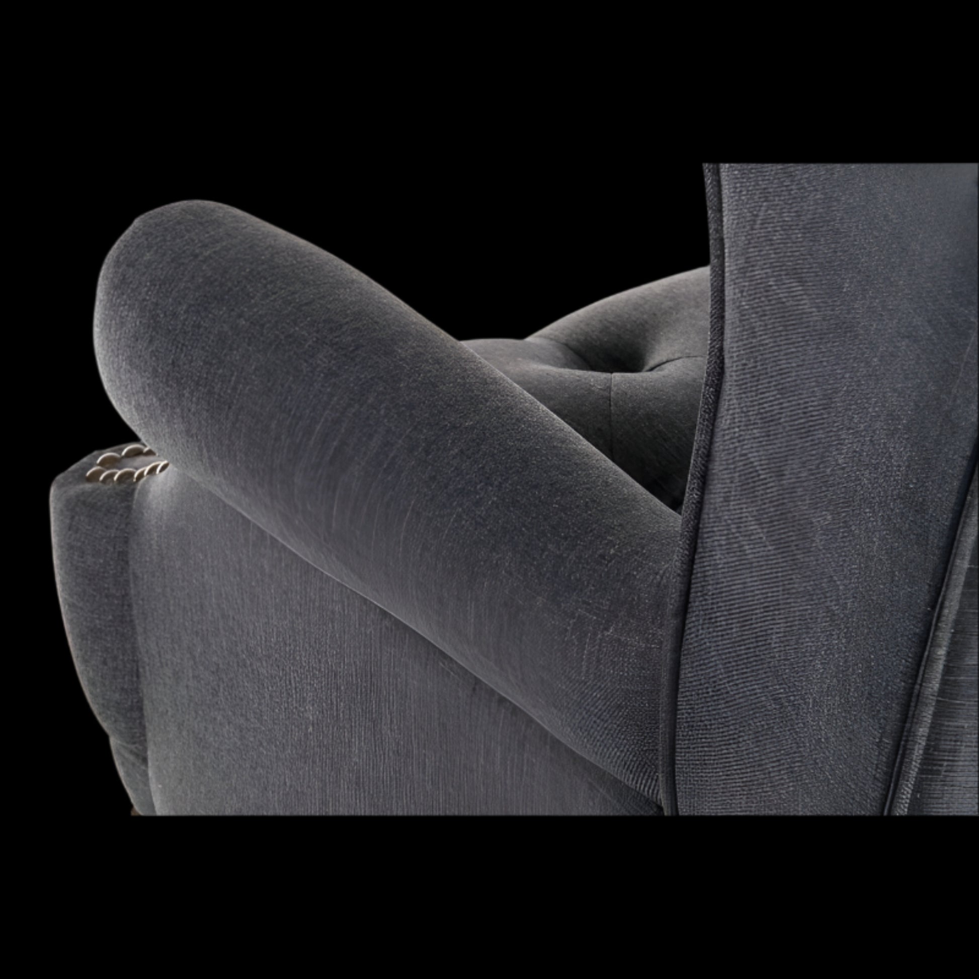 Gray upholstered chair with tufted backrest on a black background
