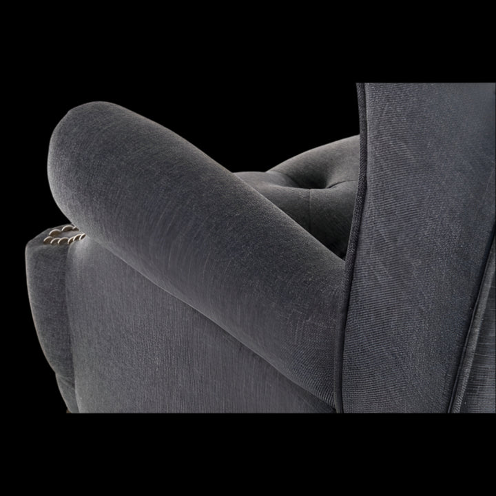 Gray upholstered chair with tufted backrest on a black background