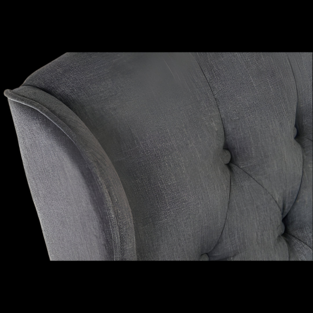 Gray upholstered chair with tufted backrest and armrests on a black background
