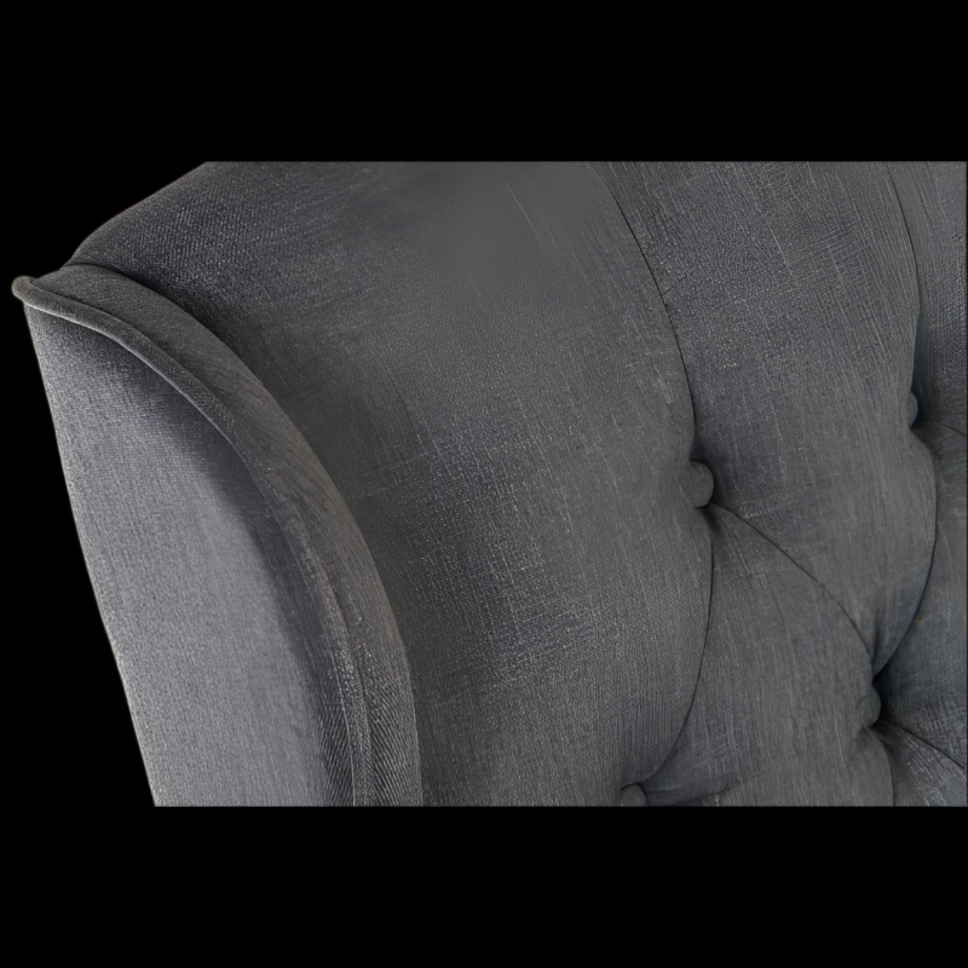 Gray upholstered chair with tufted backrest and armrests on a black background