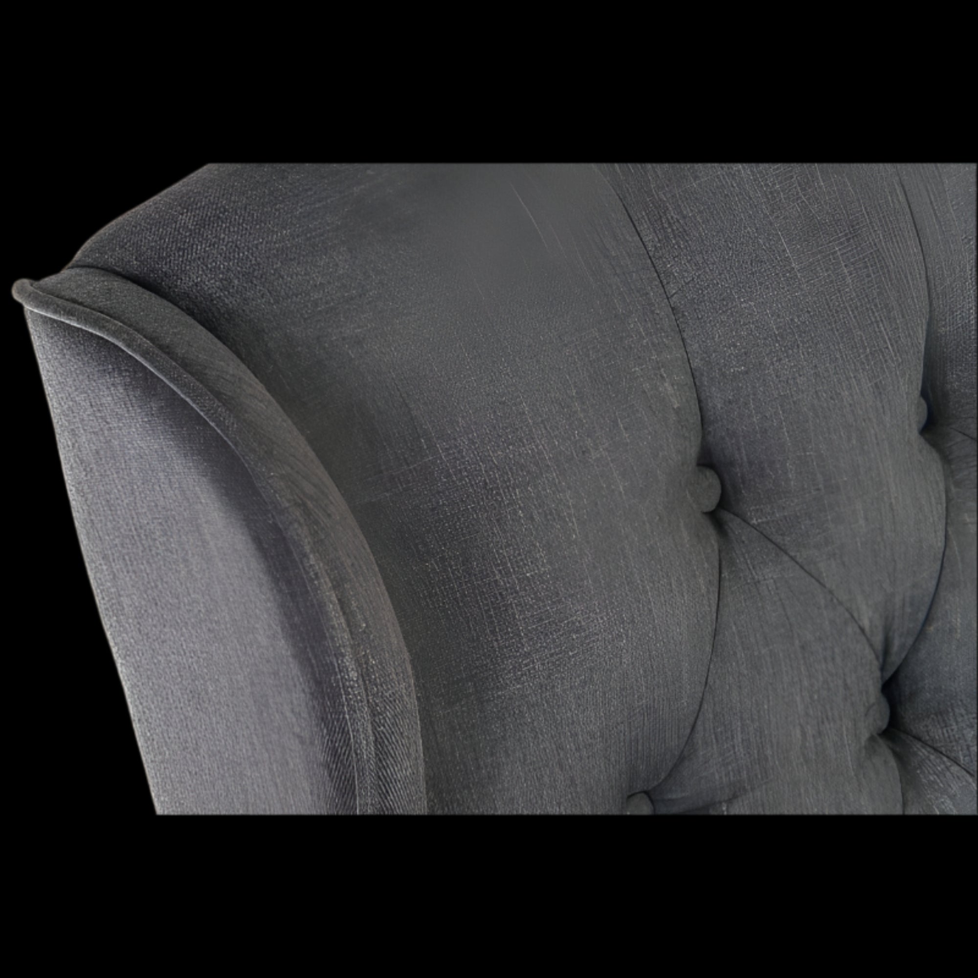Gray upholstered chair with tufted backrest and armrests on a black background