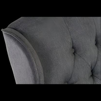 Gray upholstered chair with tufted backrest and armrests on a black background