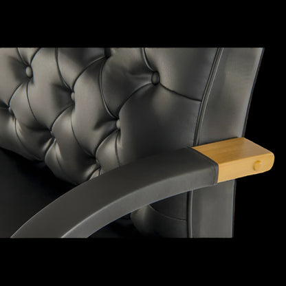 black upholstered chair with a wooden armrest on a black background