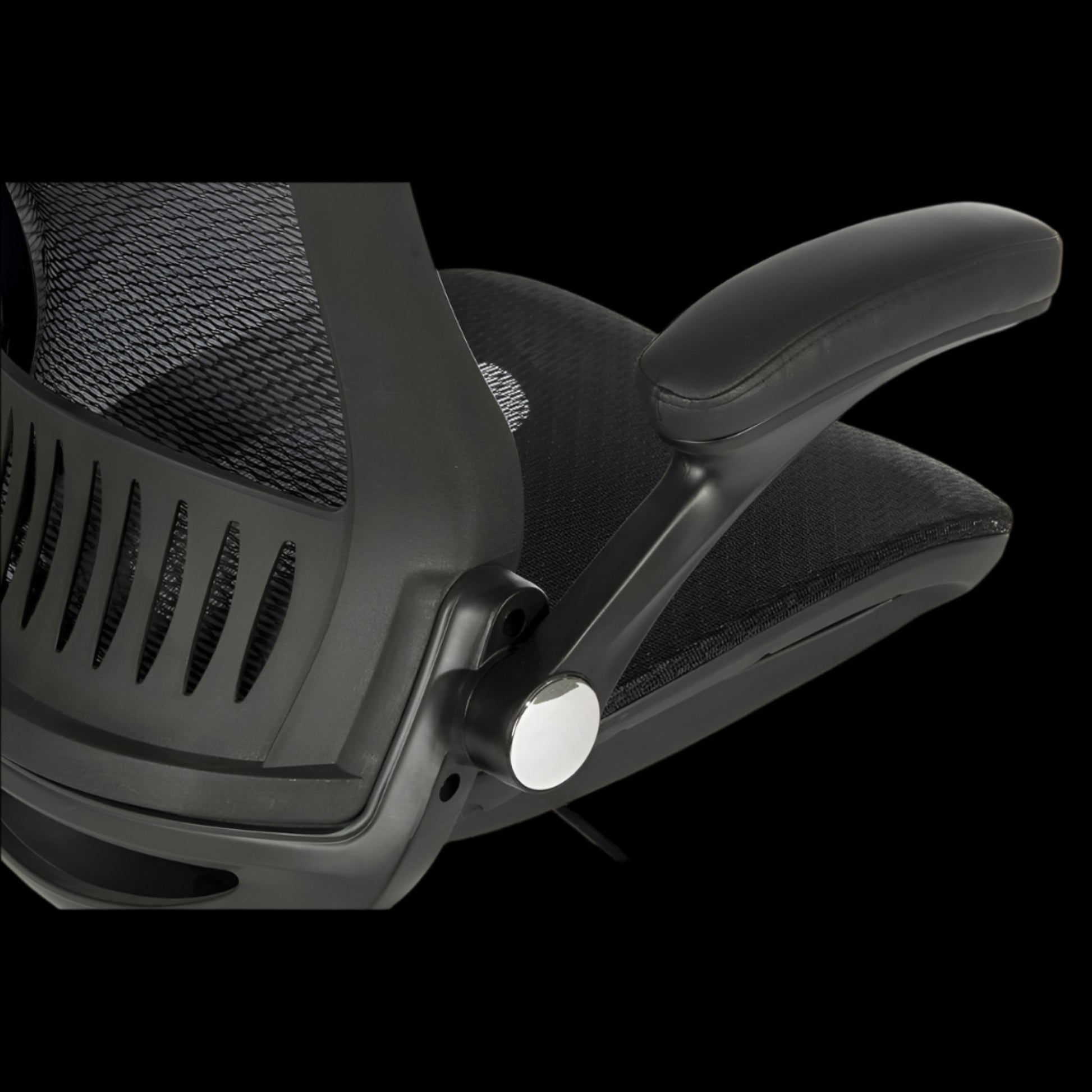 Close-up of a black office chair with mesh backrest on a black background