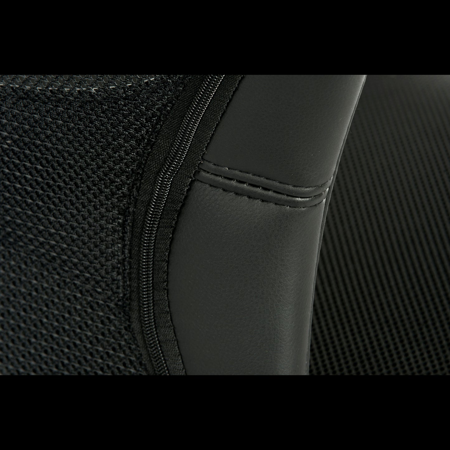 Close-up of a black office chairs backrest with mesh and stitching detail
