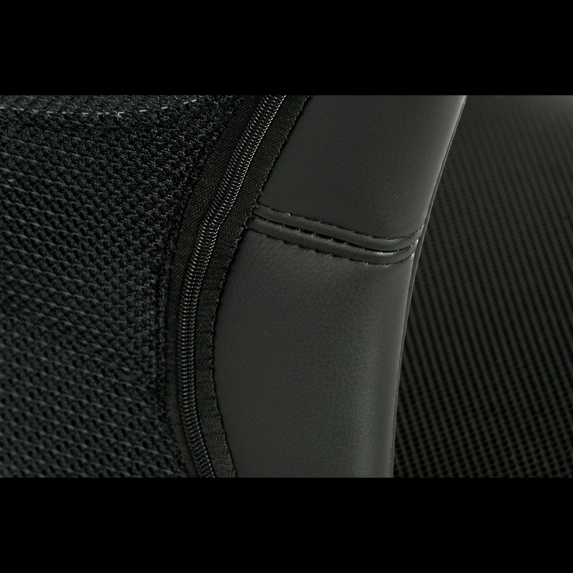 Close-up of a black office chairs backrest with mesh and stitching detail