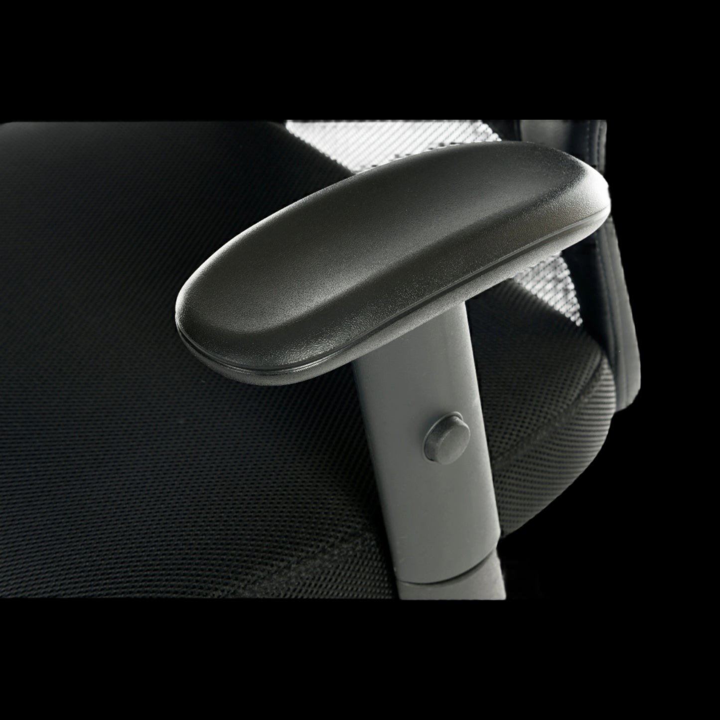 Close-up of a black office chair with armrest on a black background