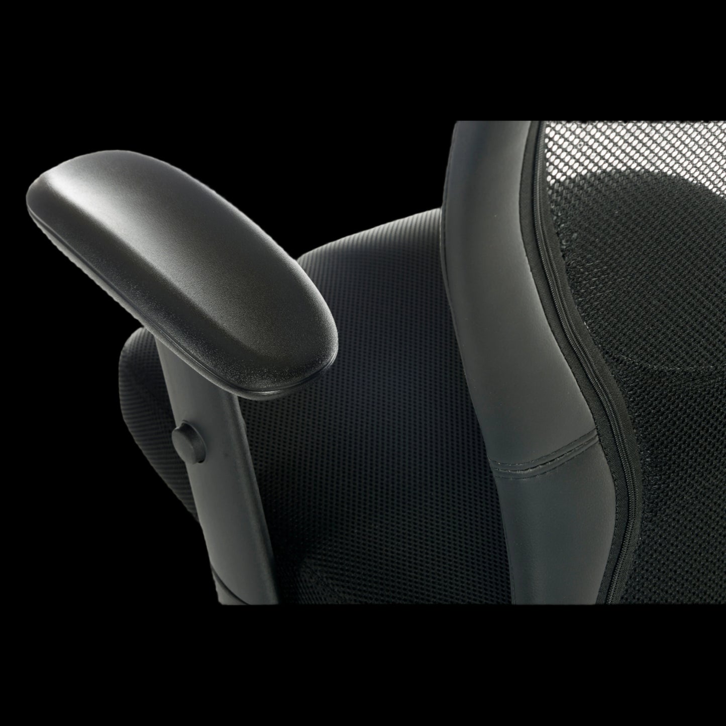 Close-up of a black office chair with armrest on a black background